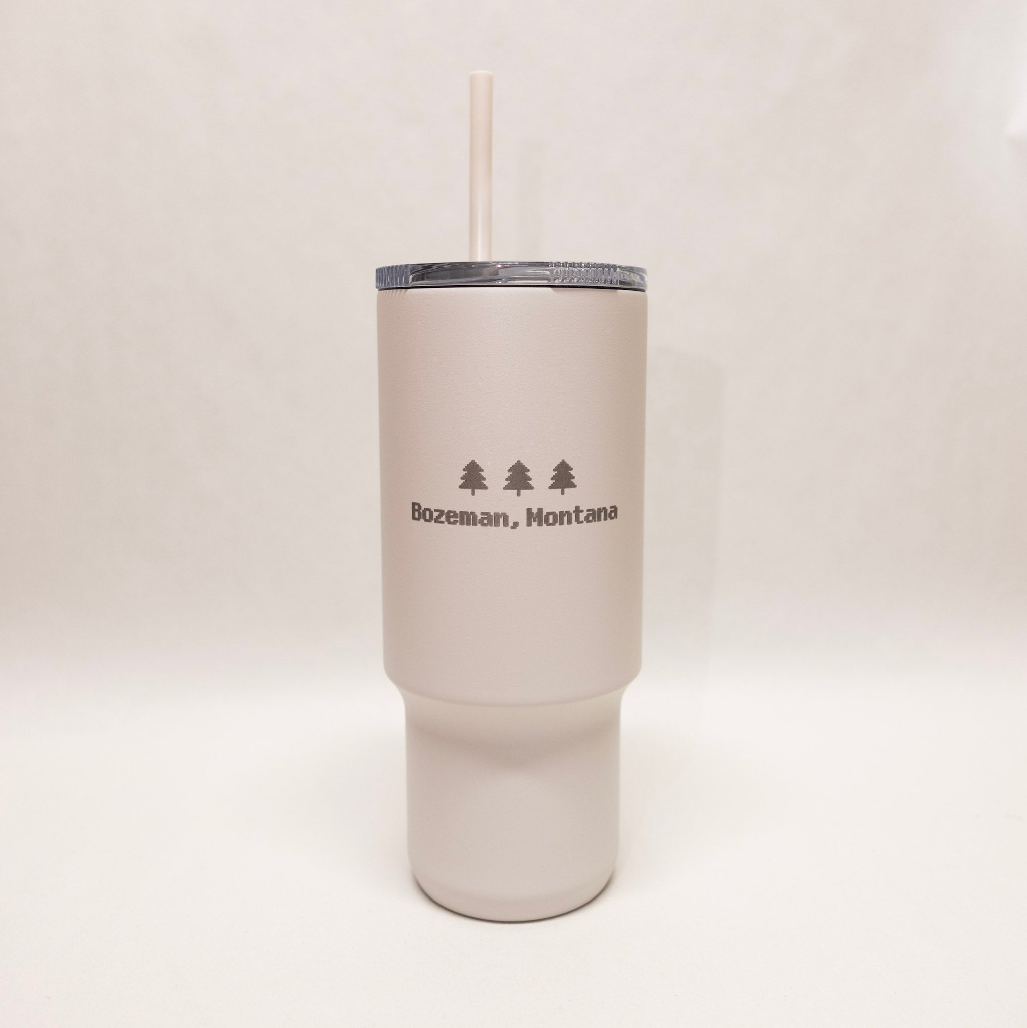 White tumbler with 'Bozeman, Montana' text and tree graphics on a white background