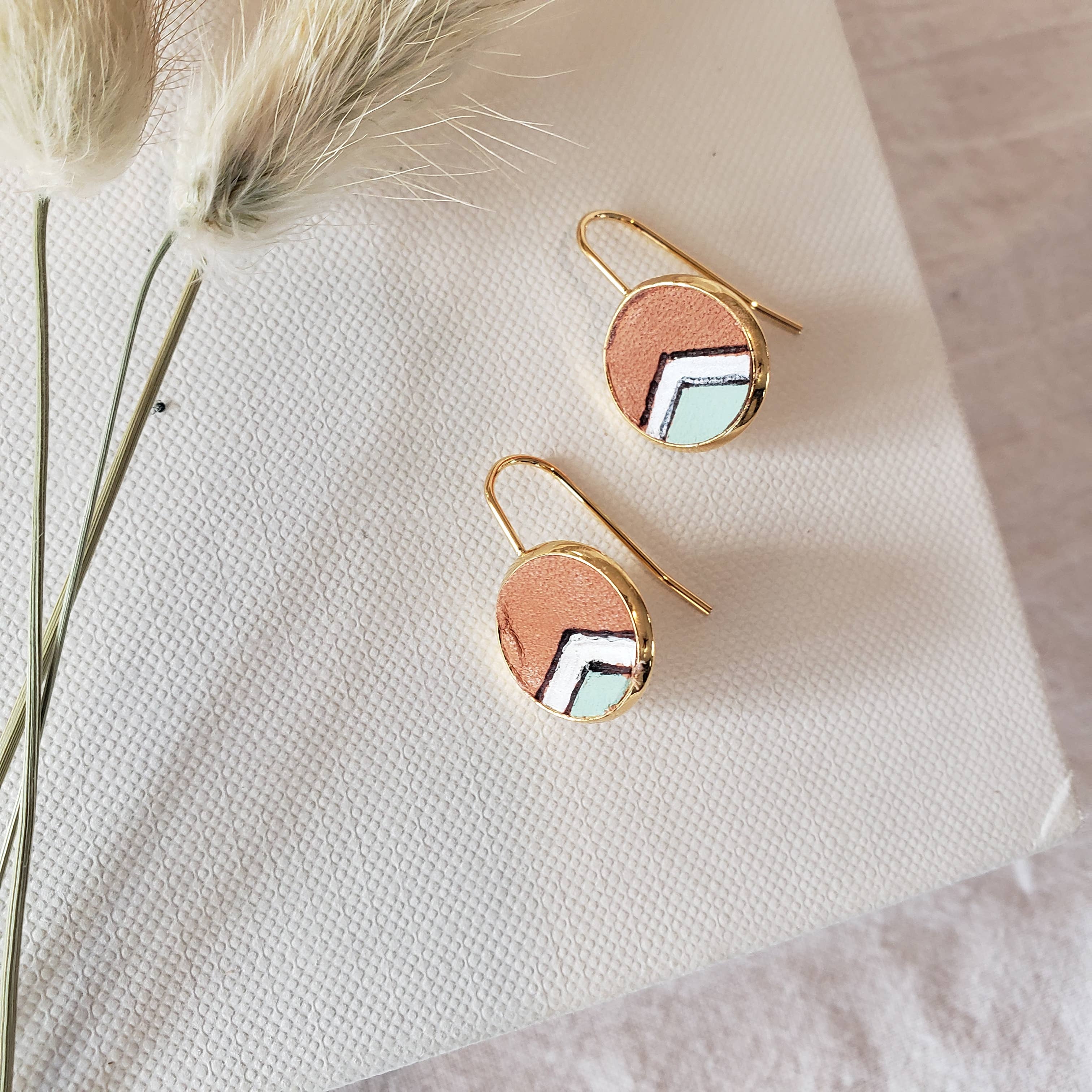 Pair of earrings with circular design on a textured surface