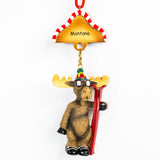 Moose ornament with skis and 'Montana' hat on a white background