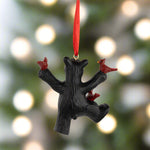 Decorative ornament shaped like a black bear with red birds on a white background