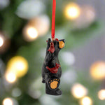 Black bear ornament with red bird on a white background