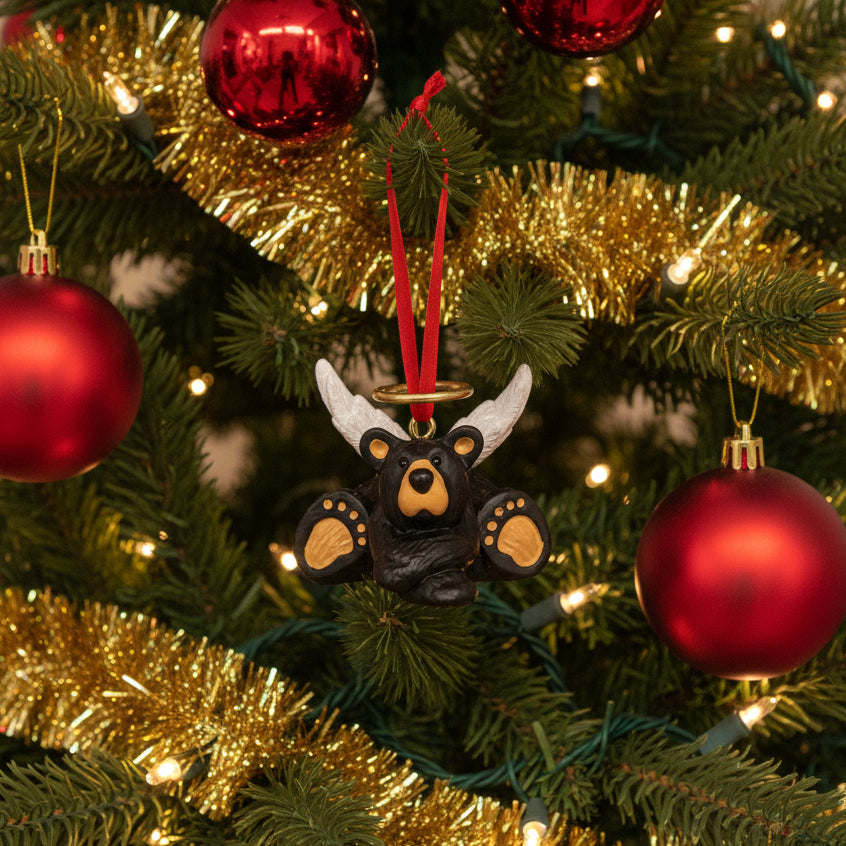 Black bear ornament with antlers on a red ribbon against a white background