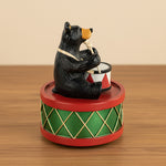 Bear playing drums figurine on a white background