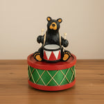 Bear playing drums figurine on a white background