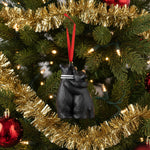 Black boxing glove ornament with a red string on a white background