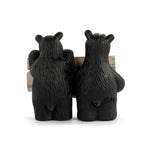 Two black bear figurines holding a wooden sign with a white background