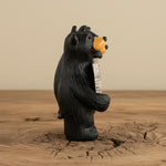 Black bear figurine holding a sign on a white background