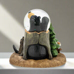 Gnome figurine inside a snow globe with a tree and log on a white background