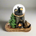 Decorative figurine with bears, a tree, and a snow globe on a white background