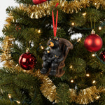 Decorative ornament of a bear and cub on a rocking chair with a red ribbon on a white background