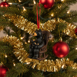 Decorative ornament of a bear and cub on a rocking chair with a red ribbon on a white background