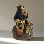 Decorative figurine of two bears with baskets of fruit and vegetables on a rock base.