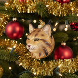 Glass ornament shaped like a bobcat head with a gold background