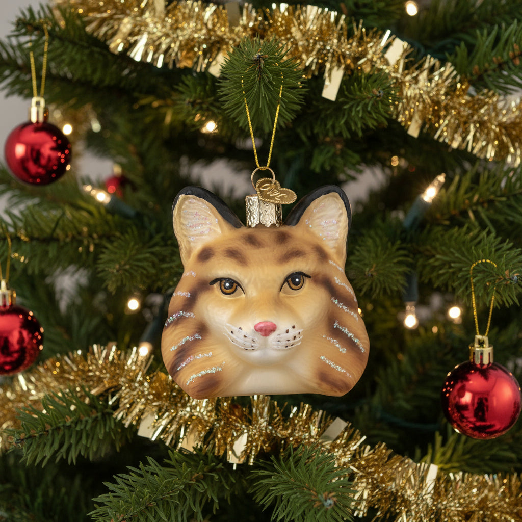 Glass bobcat ornament with glittery details on a white background
