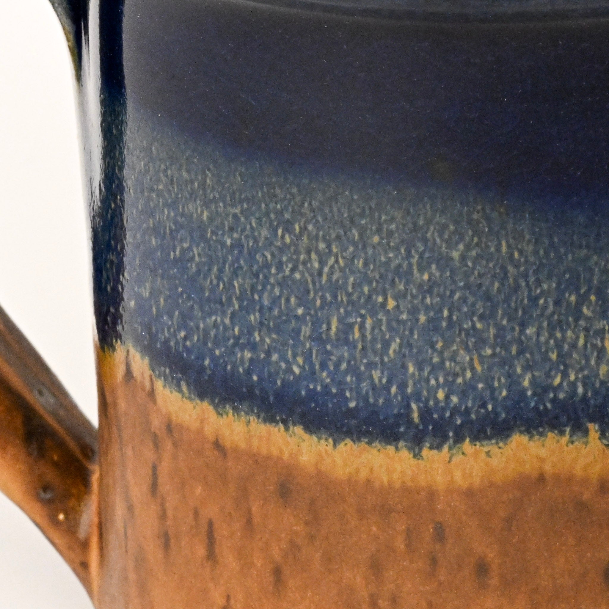 Close-up of a ceramic mug with blue and brown glaze