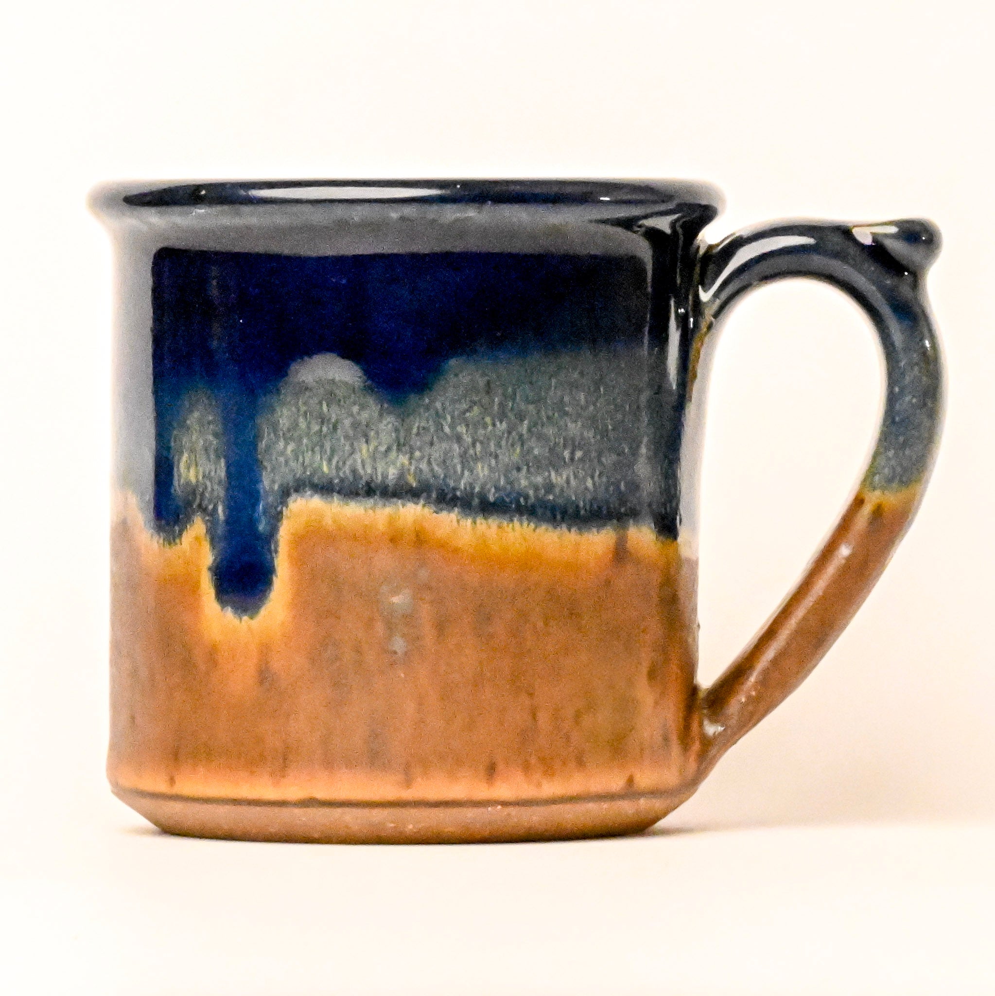 Ceramic mug with blue and brown gradient on a white background