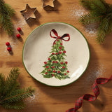 Round ceramic plate with a Christmas tree and red bow design on a speckled background