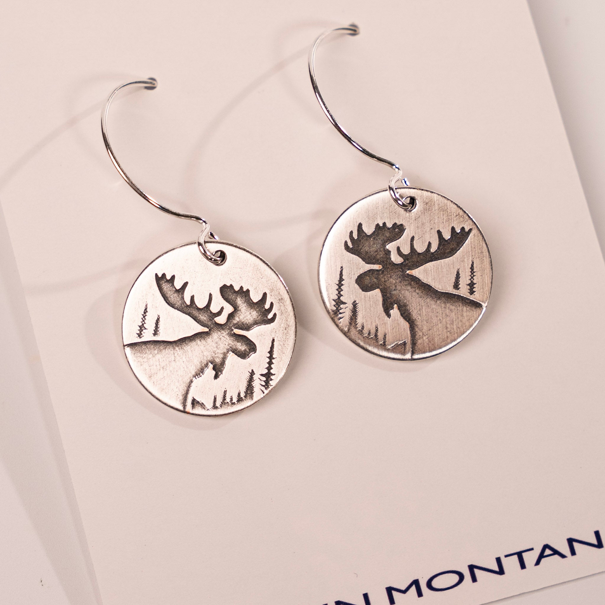 Silver moose earrings on a white card with 'In Montana' text.