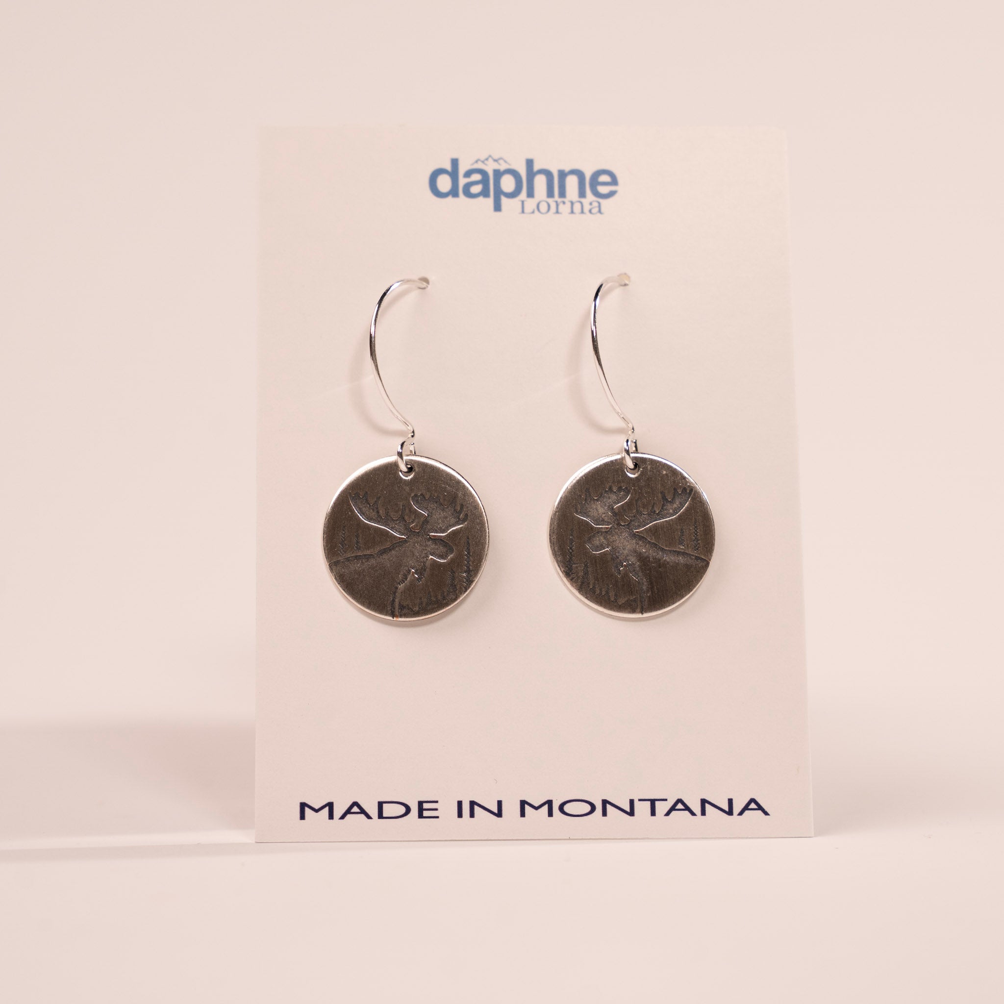 Pair of silver earrings on a Daphne Lorna branded card with 'Made in Montana' text.