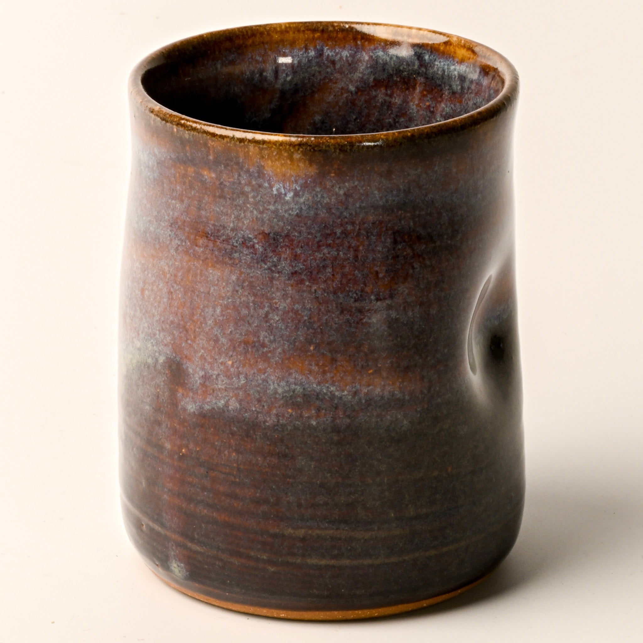 Ceramic cup with a textured surface on a light beige background