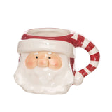 Ceramic mug shaped like a Santa face with a candy cane handle on a white background