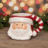 Ceramic mug shaped like a Santa face with a candy cane handle on a white background