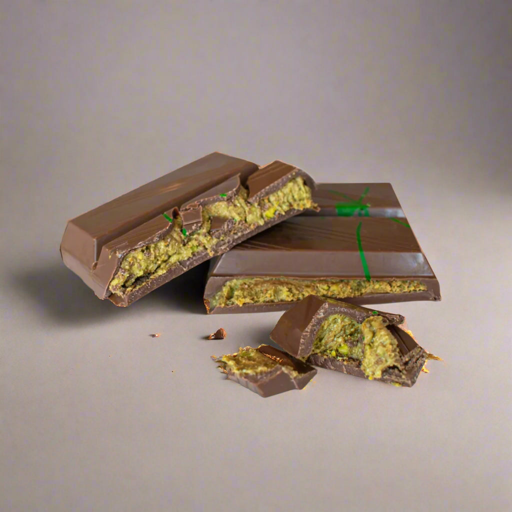 Chocolate bar with a green pistachio filling on a white background