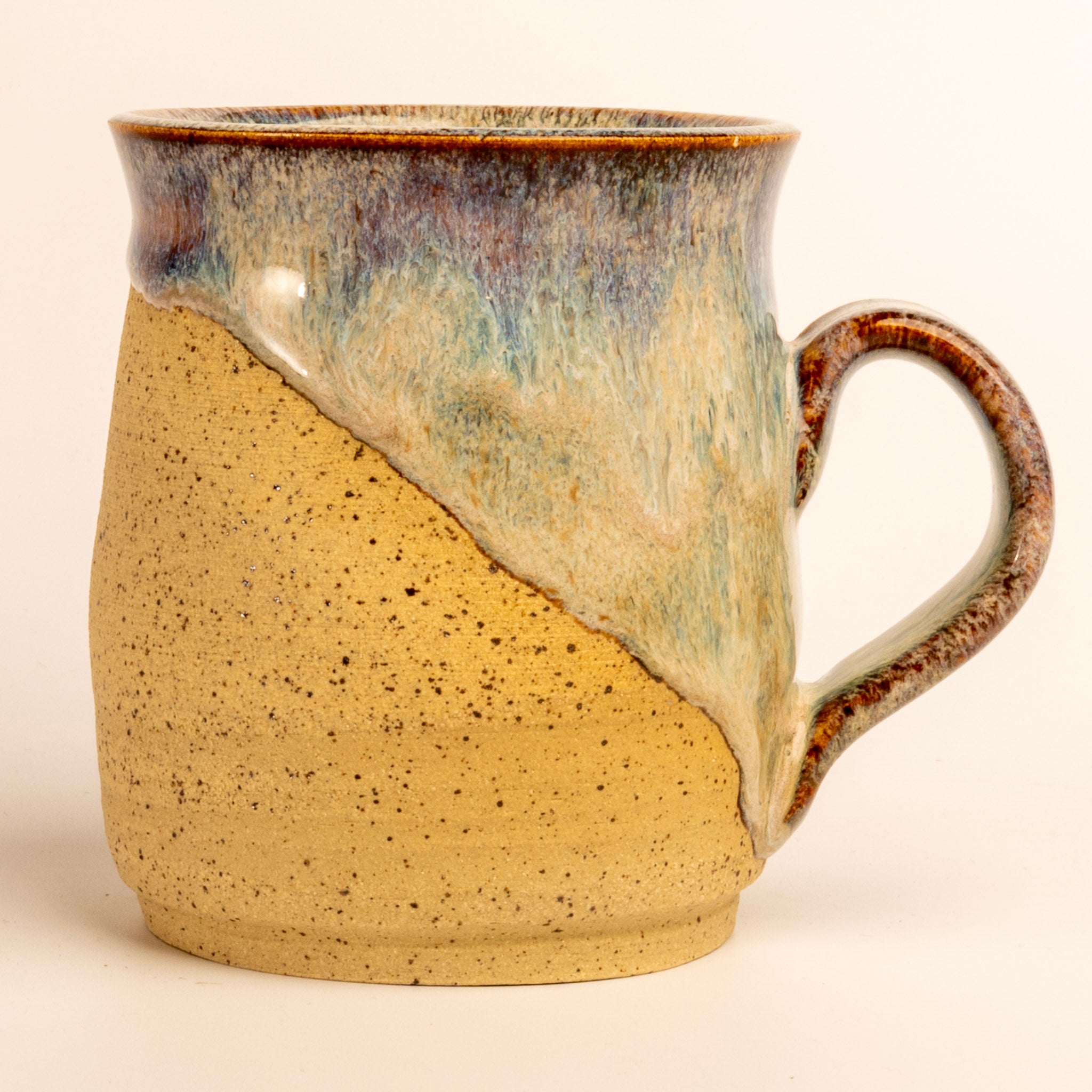 Ceramic mug with a two-tone design on a beige background