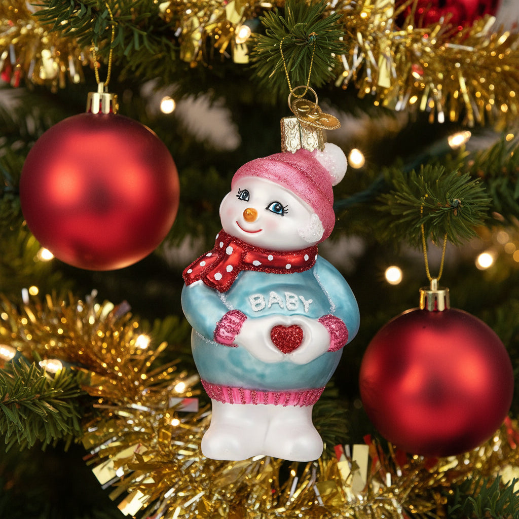 Decorative snowman ornament with 'Baby' sweater on a white background