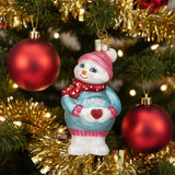 Decorative snowman ornament with 'Baby' sweater on a white background