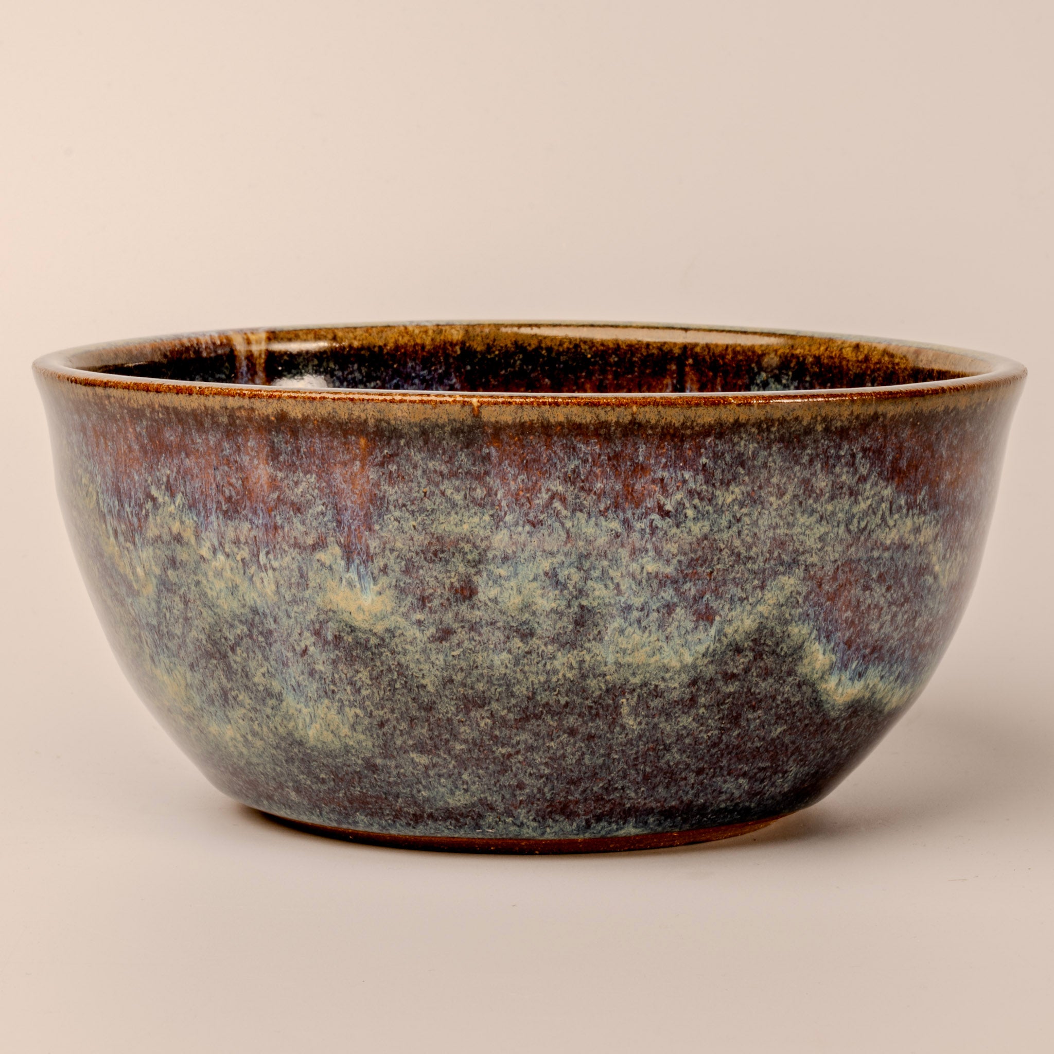 Stoneware bowl with a textured surface on a beige background