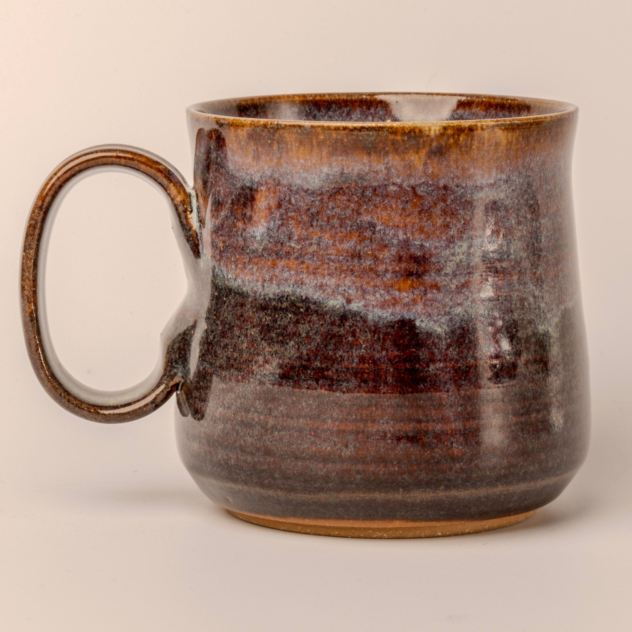 Brown ceramic mug with a textured surface on a beige background