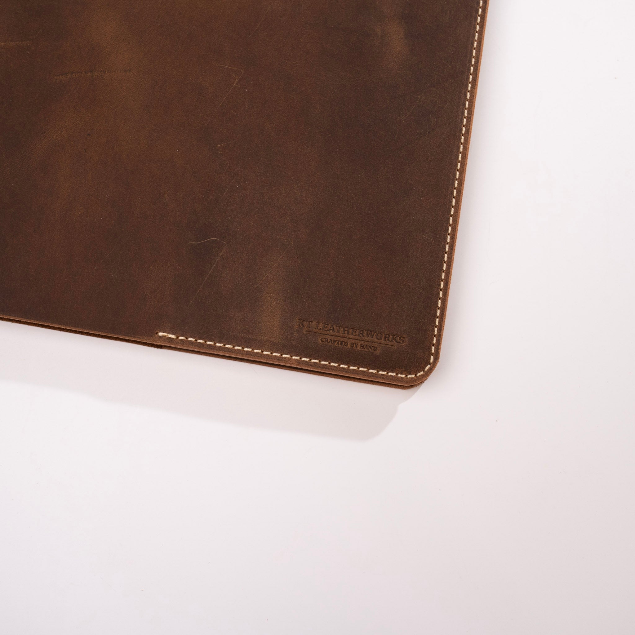 Brown leather product with visible stitching on a white background