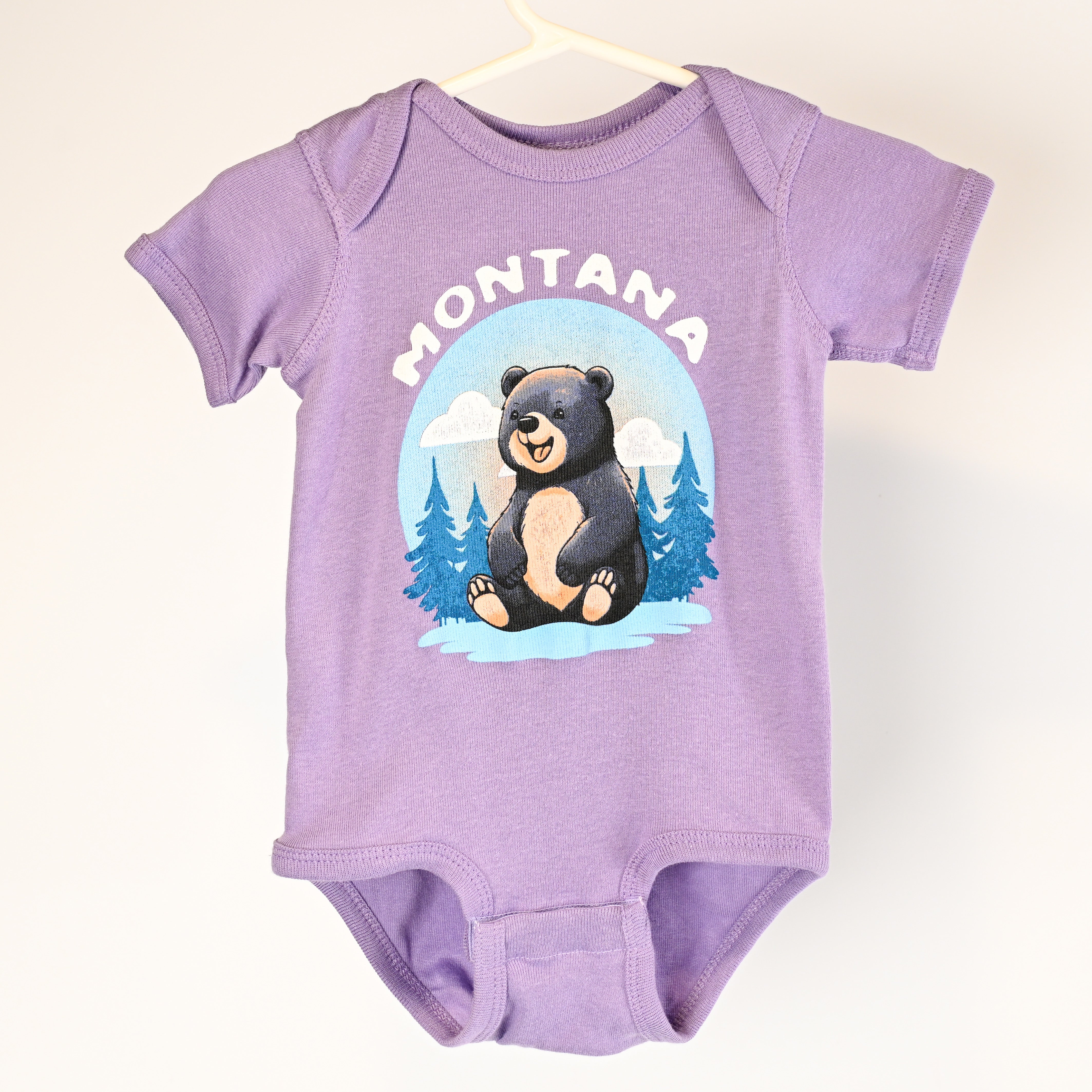 Purple baby onesie with a bear graphic and 'Montana' text on a white background