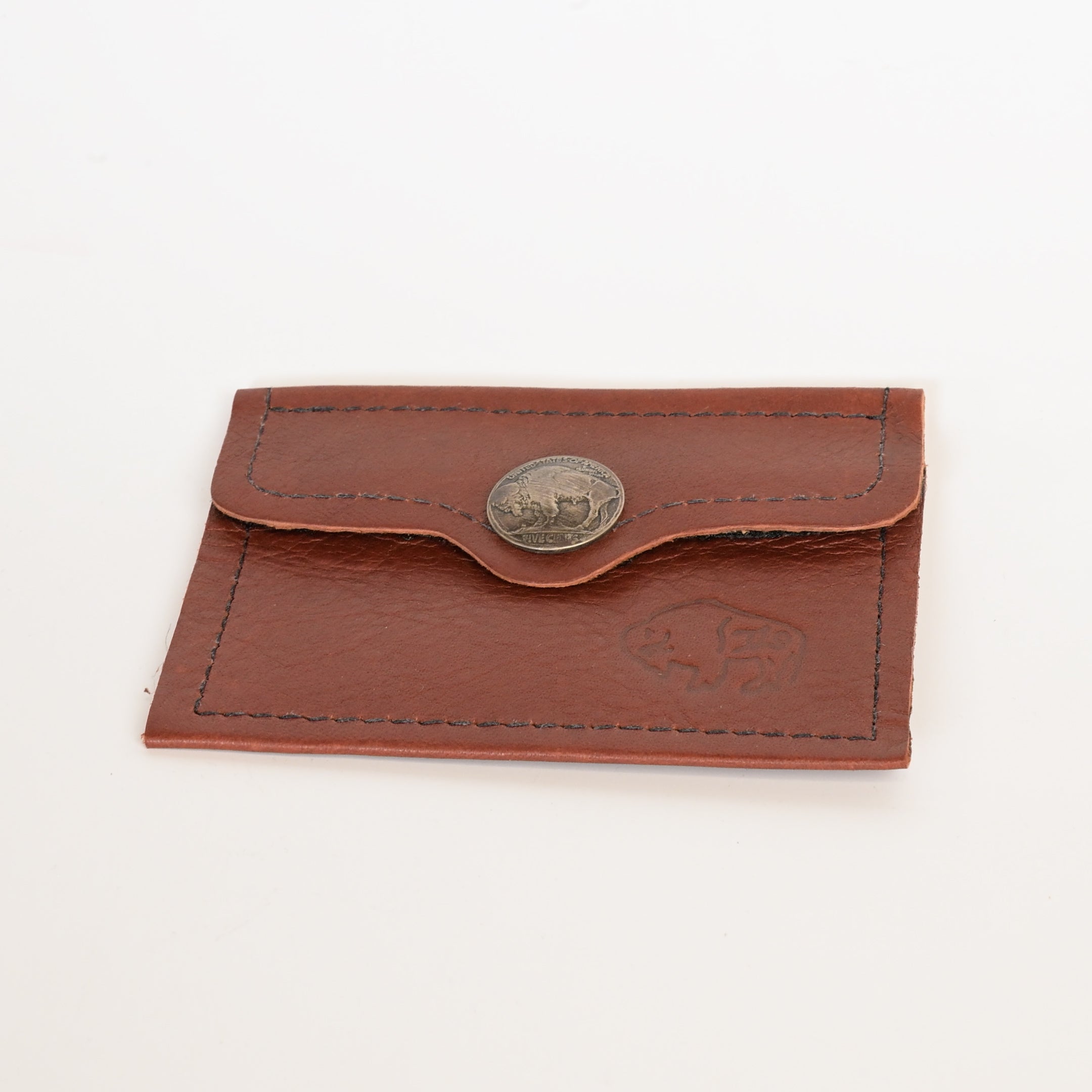 Brown leather cardholder with a button and embossed design on a white background
