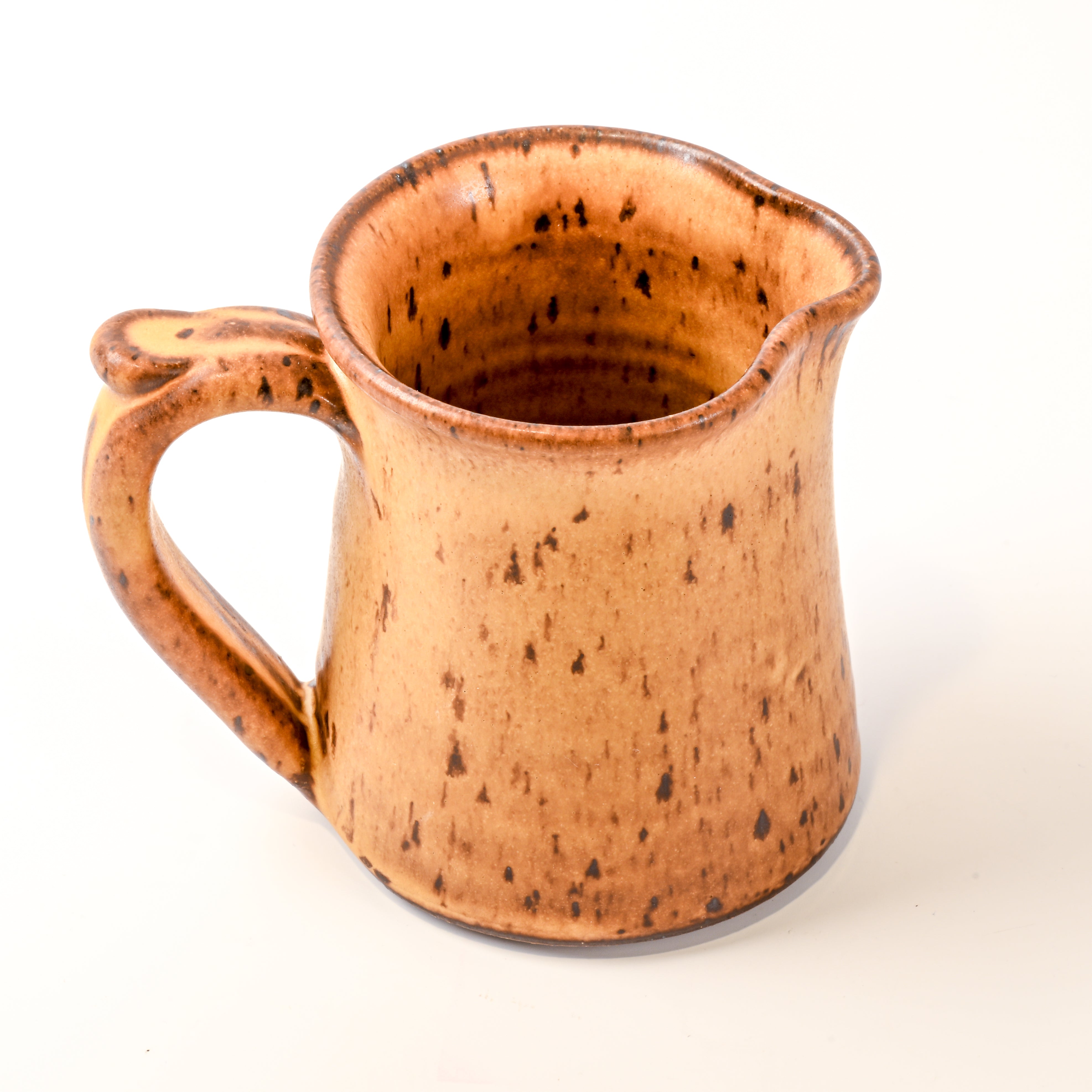 Ceramic pitcher with speckled brown glaze on a white background