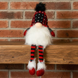 Plush gnome toy with red and black checkered hat and striped socks on a white background