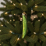 Glass ornament shaped like a pickle on a white background