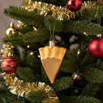 Glass ornament shaped like a slice of pie with whipped cream on a white background
