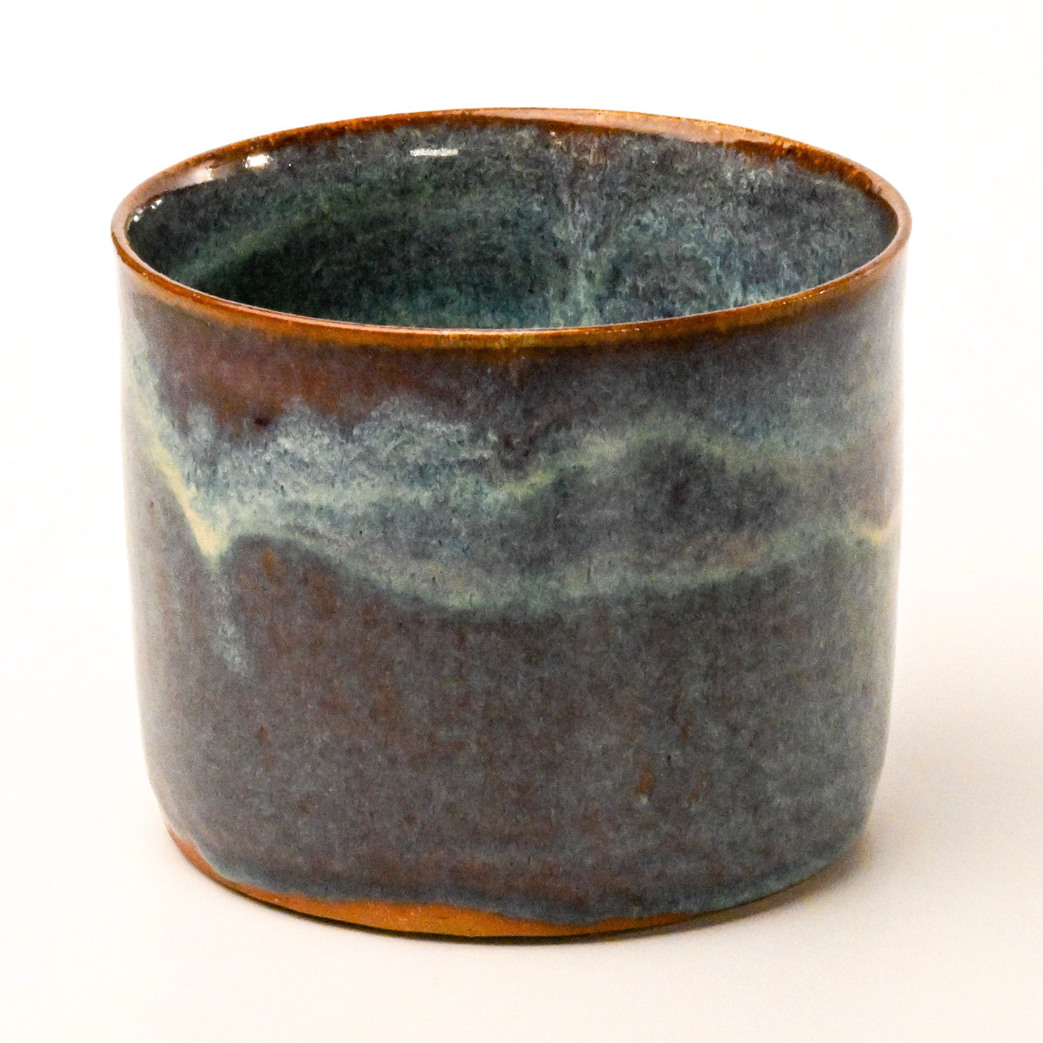 Ceramic pot with a textured blue and brown glaze on a white background