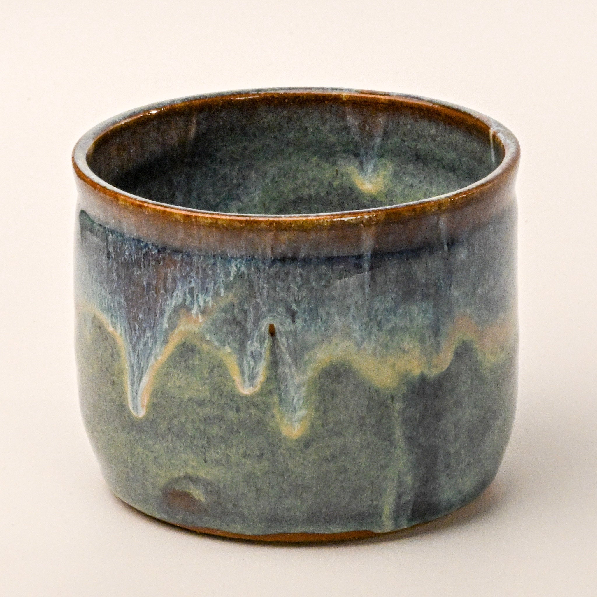 Ceramic pot with a textured glaze on a white background