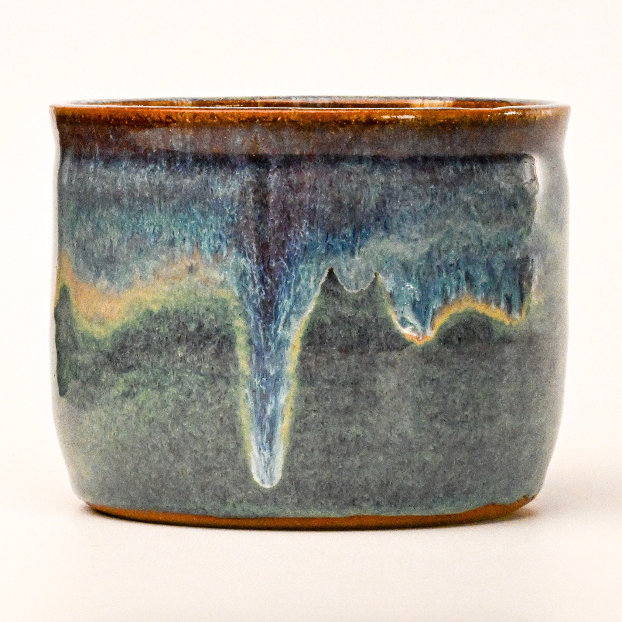 Ceramic pot with blue and brown glaze on a white background