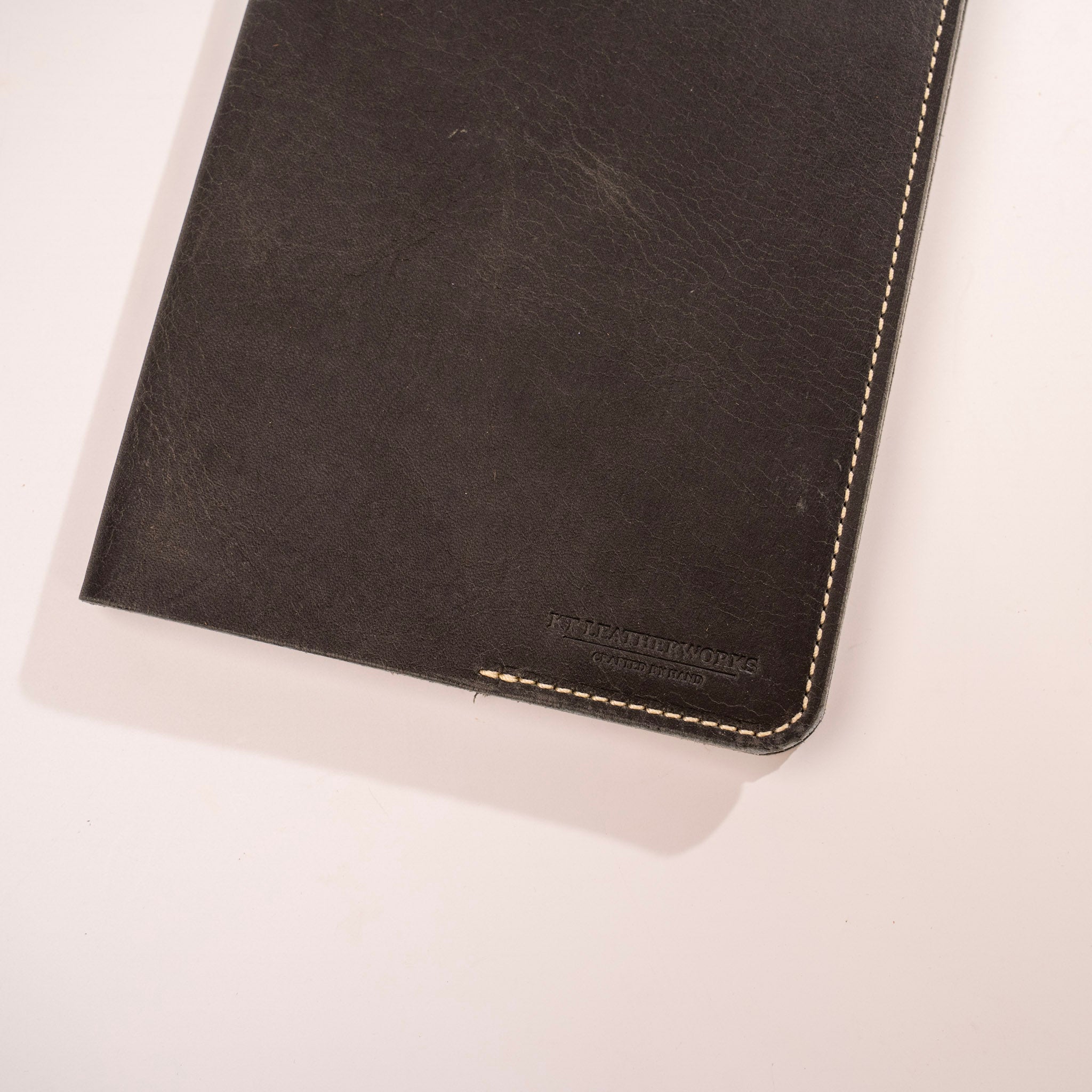 Black leather notebook with visible brand name on a white background