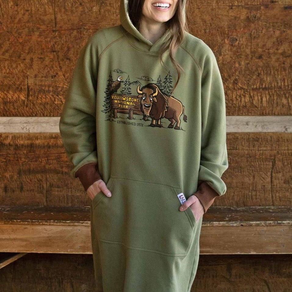 Person wearing a green hoodie with a bison design in front of a wooden background