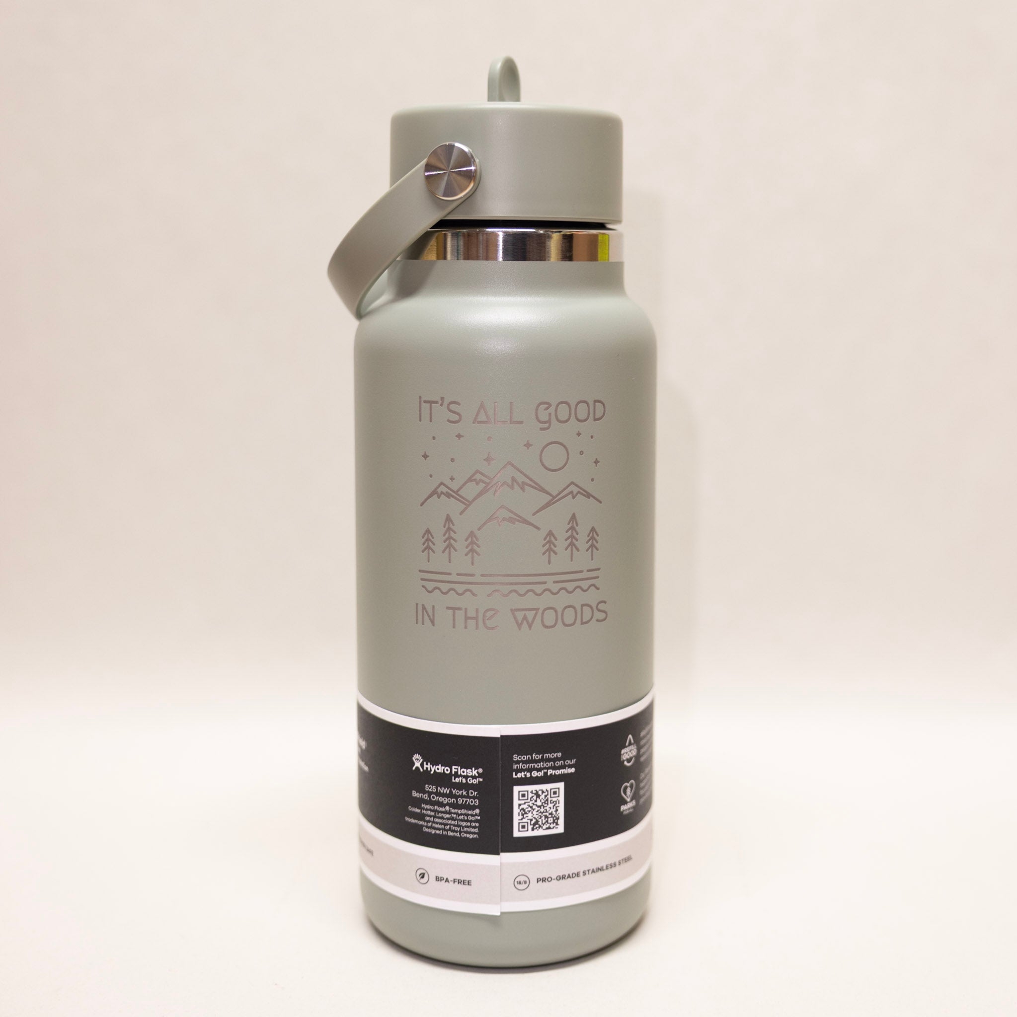 Gray water bottle with 'It's All Good in the Woods' text and mountain design on a white background
