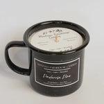 Black mug with candle inside, featuring Montana Farmhouse Candles branding.