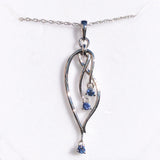 Silver pendant with blue gemstones on a white background