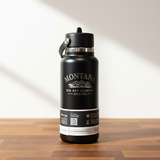 Black water bottle with Montana branding on a wooden surface