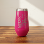 Pink tumbler with motivational quote on a wooden surface