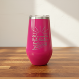 Pink tumbler with motivational quote on a wooden surface